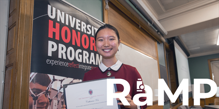 Smiling student holds Honors Program certificate from RaMP.
