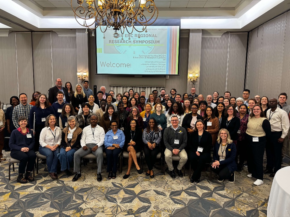 Large group of people standing and sitting in hotel conference room