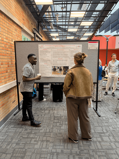 two people talking by a poster board