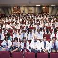 students in white coats seated