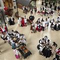 An aerial photo of a group of white coat clad students serving themselves food