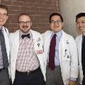 Four students in white coats pose for a photo